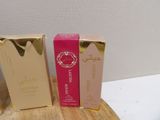 two boxes of perfume sitting on top of a wooden table