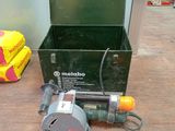 a green box with a tool on the floor next to it