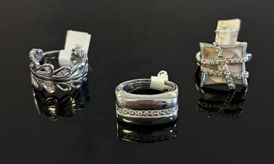 Trois anneaux différents sont représentés sur une surface noire.