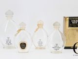 trois flacons de parfum sont posés les uns à côté des autres sur une surface blanche