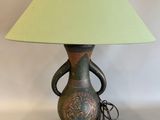 une lampe surmontée d'un abat-jour vert