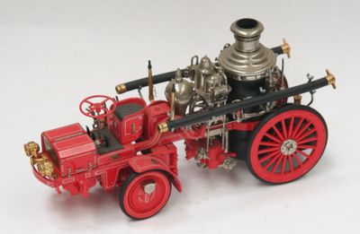 un camion de pompiers miniature posé sur une surface blanche