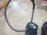 un aspirateur posé sur le sol d'une pièce