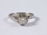 a close up of a diamond ring on a white surface