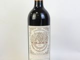 une bouteille de vin rouge posée sur une table blanche