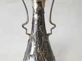 an antique silver plated vase on a white surface with a white background