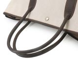 the large canvas tote bag has two handles and a brown leather strap