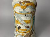 un vase blanc orné d'un motif jaune et bleu