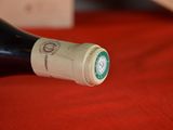a bottle of wine sitting on a red table cloth