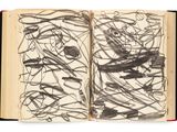 an open book with black and white drawing on it on a white surface