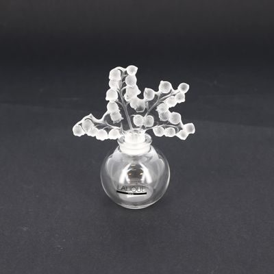 un vase en verre contenant des fleurs, posé sur une surface noire