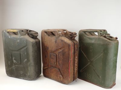 trois jerrycans sont alignés les uns à côté des autres sur une surface blanche