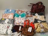 plusieurs sacs de vêtements et un sac à main posés sur la table