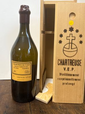 une bouteille de vin à côté d'une caisse en bois sur une table