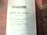 un livre posé sur une table, à côté d'une pile de livres