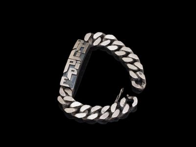 gros plan d'un bracelet en argent sur fond noir