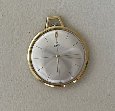 une montre-bracelet en or avec un cadran blanc sur une surface blanche