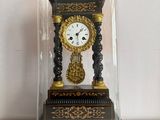 une petite horloge sous un dôme de verre sur une table