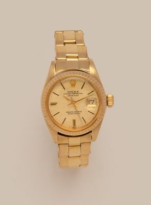 an image of a gold rolex watch on a white surface