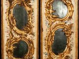 two gold framed mirrors with floral designs on them on a black background