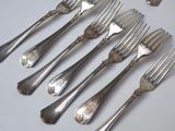a lot of forks and spoons that are on the table