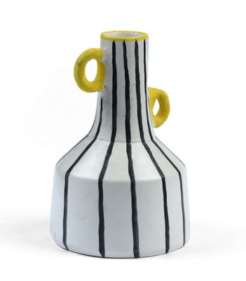 a white and black striped vase with yellow handles