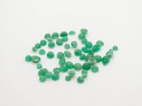a pile of green glass beads on a white surface
