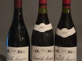 trois bouteilles de vin sont alignées sur une table