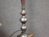 une lampe en argent posée sur une table rouge