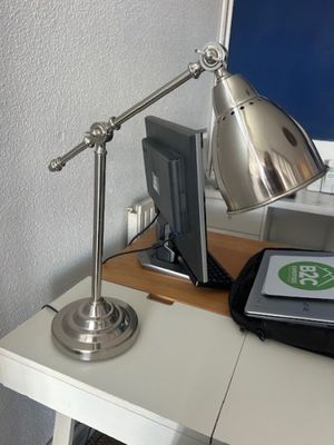 a desk with a laptop and a lamp on it