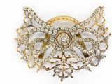 an image of a gold and diamond broochle on a white background