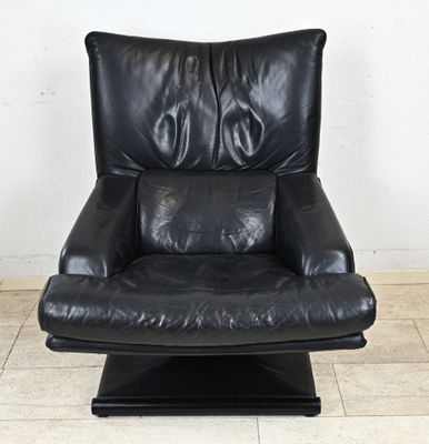une photo d'un fauteuil inclinable en cuir noir avec un piètement noir