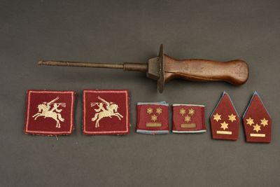 plusieurs insignes militaires et un couteau en bois posés sur une table