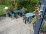 a table and chairs on the patio outside of the house