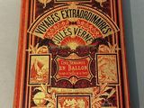 an old book on a table with a red cover