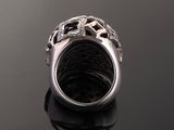 a close up of a silver ring with diamonds on a black surface