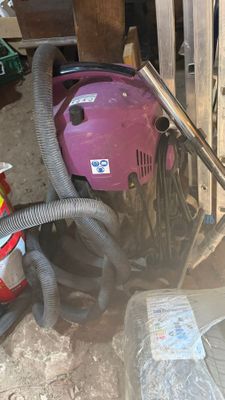 un aspirateur posé par terre à côté d'une pile de cartons