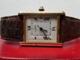 une petite montre carrée dont le cadran est orné de chiffres romains