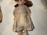 several antique dolls are on display in a glass case