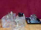trois flacons de parfum posés sur une table à côté d'un téléphone portable