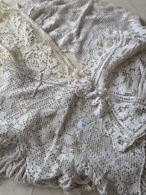 deux vêtements blancs au crochet posés sur un lit