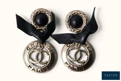 deux paires de boucles d'oreilles ornées d'un ruban noir sur un fond blanc