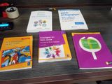 plusieurs livres posés sur une table, avec un téléphone portable à côté