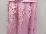 pink dress hanging on a hanger in front of a white wall