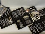 many forks and spoons in a case on the table