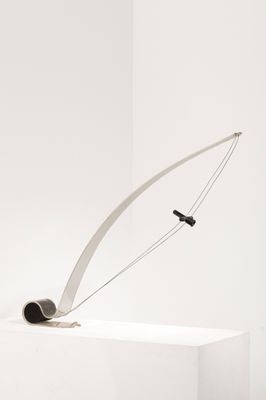 une sculpture représentant une canne à pêche posée sur un socle blanc