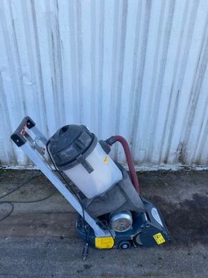 a vacuum that is sitting on the ground next to a wall