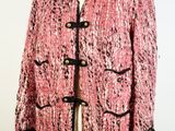 a pink jacket with black trims and buttons on a mannequin mannequin