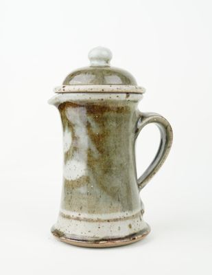 a close up of a coffee pot on a white surface