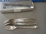 four forks and a knife on a table next to a keyboard